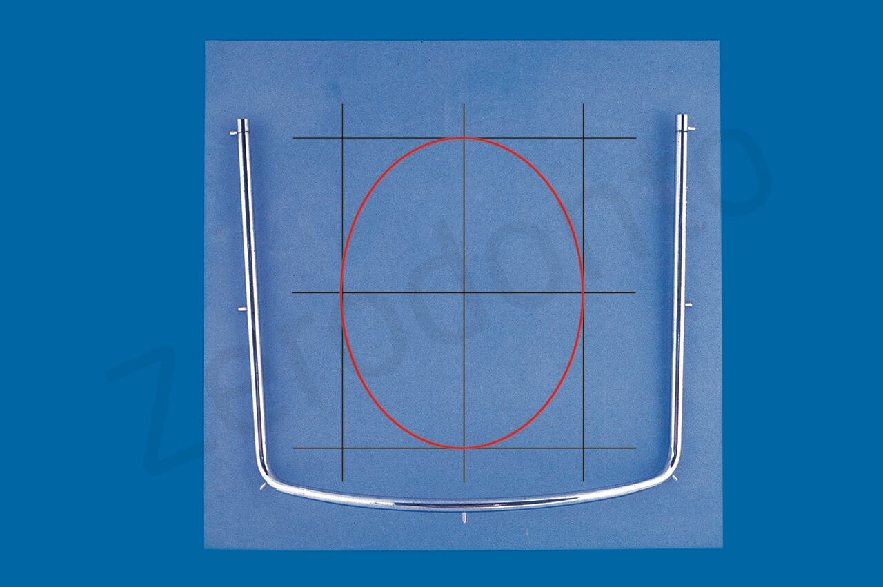 Per decidere dove eseguire il foro nel foglio di diga, si possono tracciare mentalmente tre linee verticali e tre orizzontali. L’ellisse inscritta nel rettangolo centrale corrisponde alle due arcate dentarie.